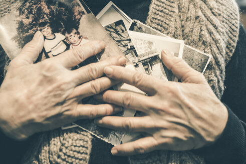 Hände einer älteren Frau, die alte Fotografien hält, Nahaufnahme - DEGF000607