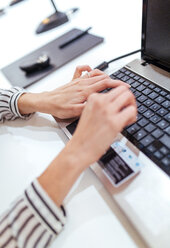 Hände einer jungen Geschäftsfrau bei der Arbeit mit einem Laptop, Nahaufnahme - MGOF001334