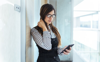 Young businesswoman looking at her smartphone - MGOF001344