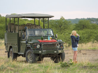 Namibia, Outjo, Tourist trinkt ein Glas Champagner im Ongava Wildreservat - AMF004760