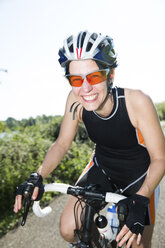 Porträt eines glücklichen Rennradfahrers mit Sonnenbrille und Fahrradhelm - JATF000836