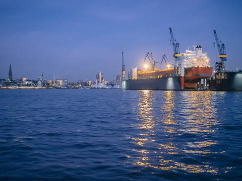 Deutschland, Hamburg, Hafen, Containerschiff in einem Dock am Abend, lizenzfreies Stockfoto