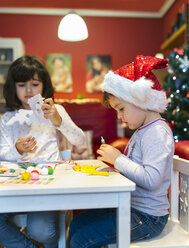 Zwei kleine Mädchen basteln Weihnachtsdekoration - MGOF001351