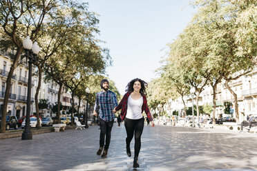 Spanien, Tarragona, glückliches junges Paar beim Laufen in der Stadt - JRFF000414
