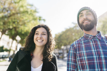 Smiling young couple outdoors looking around - JRFF000418