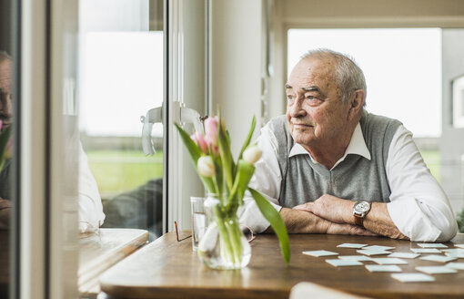 Porträt eines älteren Mannes, der durch ein Fenster schaut - UUF006591