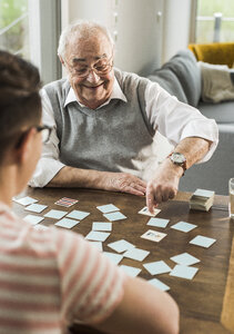 Älterer Mann spielt Memory mit seinem Enkel - UUF006599