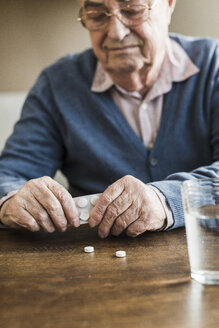 Senior man taking tablets out of blister pack, close-up - UUF006614