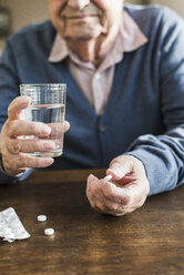 Senior man taking medicine, close-up - UUF006617