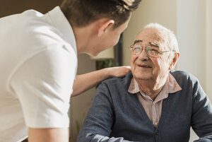 Portrait of smiling senior man face to face with his geriatric nurse - UUF006621