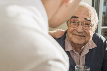 Portrait of smiling senior man face to face with his geriatric nurse - UUF006622