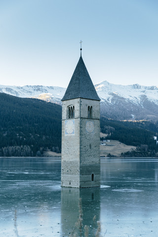 Italien, Vinschgau, Versunkene Turmspitze im zugefrorenen Lago di Resia, lizenzfreies Stockfoto