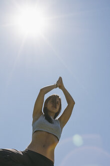 Frau macht Yoga-Übung bei Gegenlicht - ABZF000194