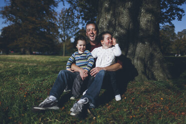 Vater und seine Kinder sitzen an einem Baum - BOYF000093