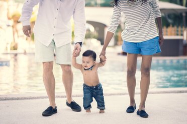 Mexico, Puerto Vallarta, baby boy learning to walk holding by hands of his parents - ABAF001979