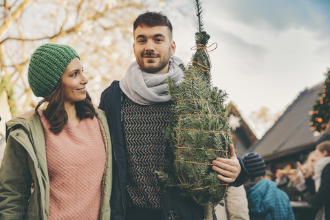 Happy couple with a tree on the Christmas Market stock photo