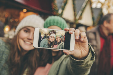 Zwei glückliche Frauen machen ein Selfie auf dem Weihnachtsmarkt - MFF002645