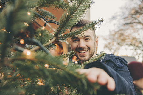 Happy young man with a tree on the Christmas Market stock photo