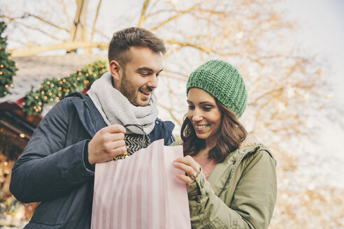 Ehepaar auf dem Weihnachtsmarkt mit Geschenktüte - MFF002661