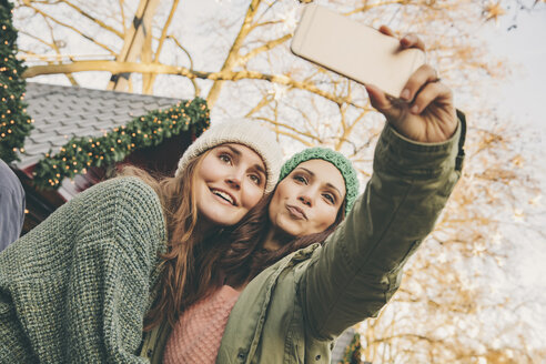 Two happy women taking a selfie on the Christmas Market - MFF002666