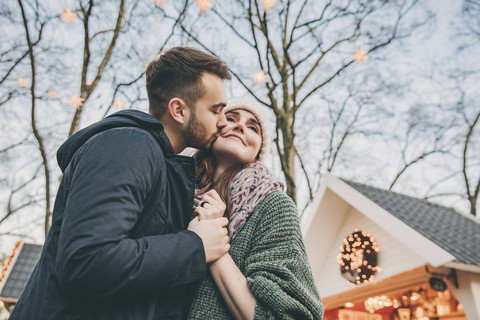 Man kissing woman on the cheek on the Christmas Market stock photo