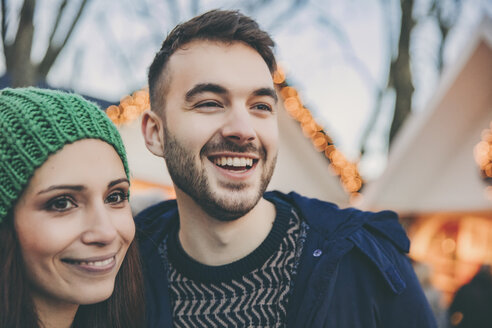Ein lächelndes Paar schaut sich auf dem Weihnachtsmarkt um - MFF002689
