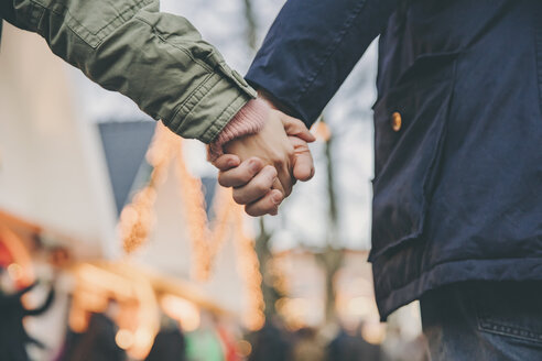 Close-up of couple holding hands on the Christmas Market - MFF002690