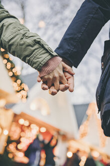 Close-up of couple holding hands on the Christmas Market - MFF002691