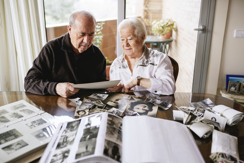 Senior couple watching their old photographies and photo albums at home stock photo