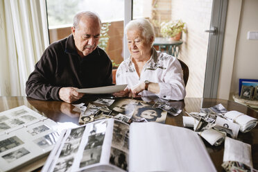 Ein älteres Ehepaar betrachtet zu Hause seine alten Fotos und Fotoalben - GEMF000720