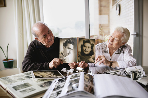 Älteres Paar zeigt alte Bilder von sich, lizenzfreies Stockfoto