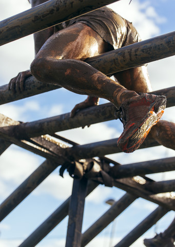 Teilnehmer des Extrem-Hindernisrennens klettern auf dem Affengitter, lizenzfreies Stockfoto