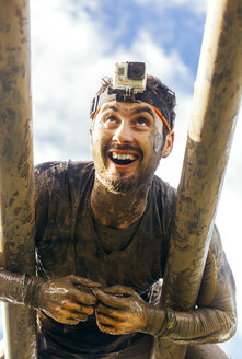 Participants in extreme obstacle race climbing on monkey bars - MGOF001401