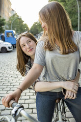 Zwei Mädchen im Teenageralter zusammen auf einem Fahrrad - OJF000108