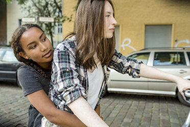 Zwei Mädchen im Teenageralter zusammen auf einem Fahrrad - OJF000110