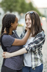 Two happy teenage girls hugging outdoors - OJF000113