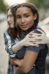 Zwei Teenager-Mädchen umarmen sich im Freien - OJF000114