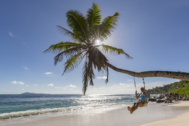 Seychellen, La Digue, Anse Fourmis, Strand mit Palme und Tourist auf Schaukel - FOF008399