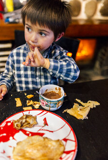 Porträt eines kleinen Jungen, der Pfannkuchen isst und heiße Schokolade trinkt - MGOF001420