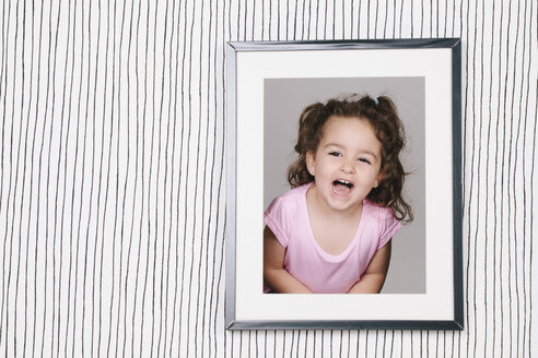 Framed photography of little girl hanging on striped wallpaper - ERLF000130