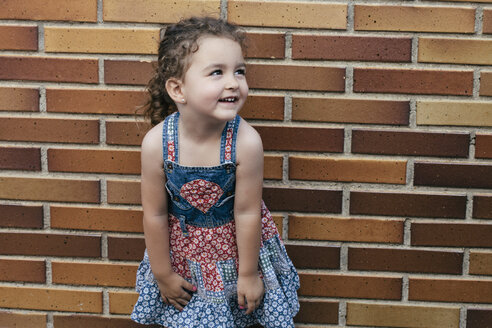 Portrait of smiling little girl wearing patterned summer dress - ERLF000132