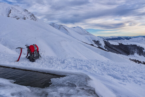 Italien, Umbrien, Monti Sibillini National Park, Sonnenuntergang auf dem Berg Redentore im Winter, Eispickel und Rucksack - LOMF000215