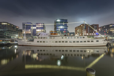 Deutschland, Hamburg, Historisches Schiff vor der modernen Architektur der Hafencity bei Nacht - NK000454