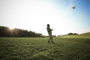 Man on a meadow flying drone - REAF000025