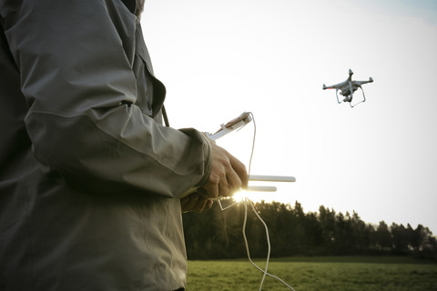 Man on a meadow flying drone stock photo
