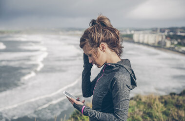 Porträt einer sportlichen Frau mittleren Alters, die ein Smartphone benutzt - DAPF000044