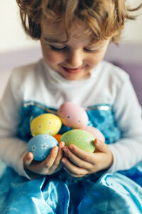 Glückliches kleines Mädchen mit Ostereiern in der Hand - MGOF001422