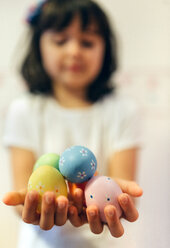 Girl's hands holding painted Easter eggs - MGOF001425