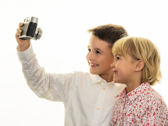 Lächelnder Bruder und lächelnde Schwester machen ein Selfie mit altmodischer Kamera - EJWF000769