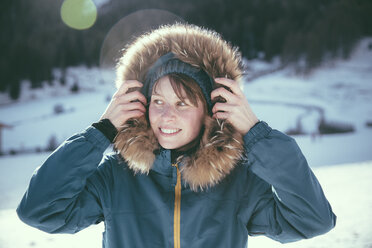 Italy, Val Venosta, Slingia, smiling woman with fur hood in winter landscape - MFF002718